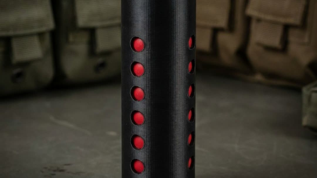 Close-up of the VIO Modular Air Gun Moderator side holes showing the removable red bafflers